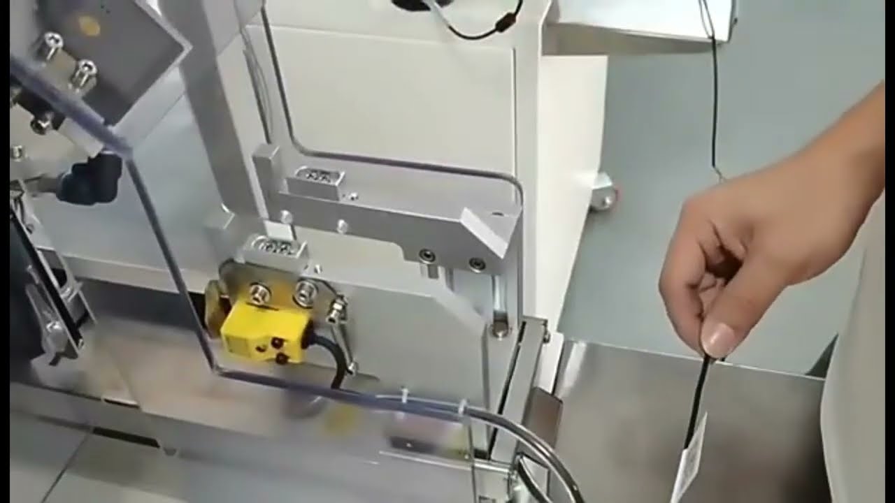 USBイヤホン線材用 自己粘着フラグラベリングマシン | ワイヤーハーネス結束・ラベル貼付機